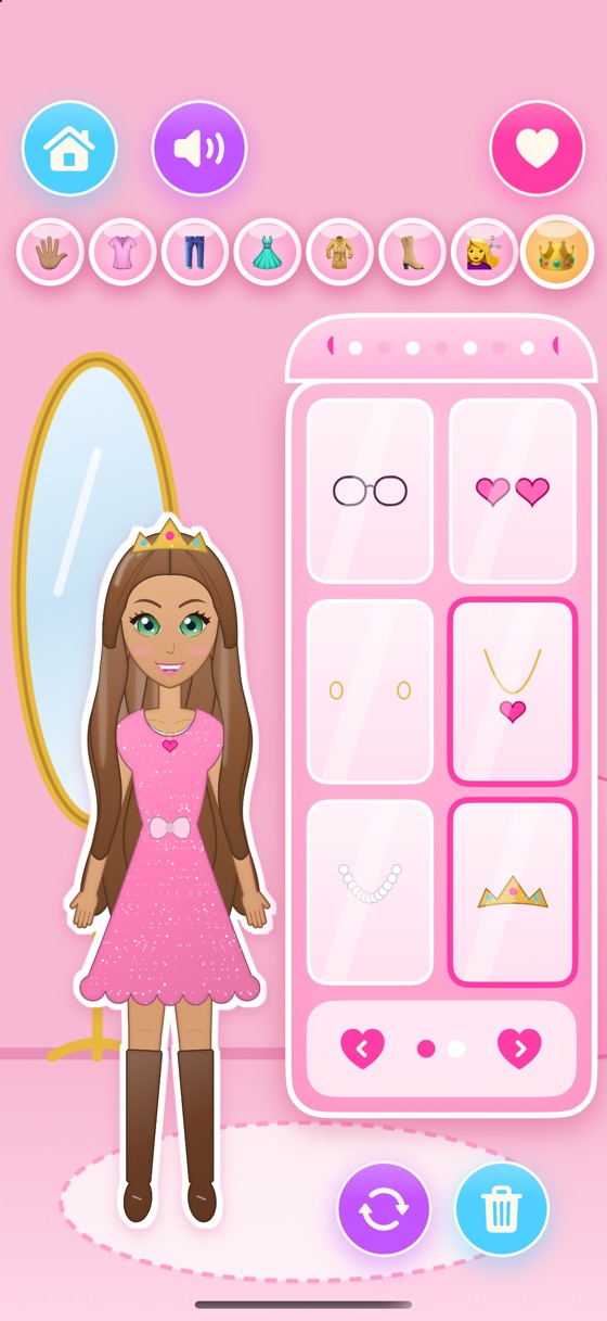A paper doll with green eyes in a sparkly pink dress, boots, a heart necklace and a tiara, next to a wardrobe